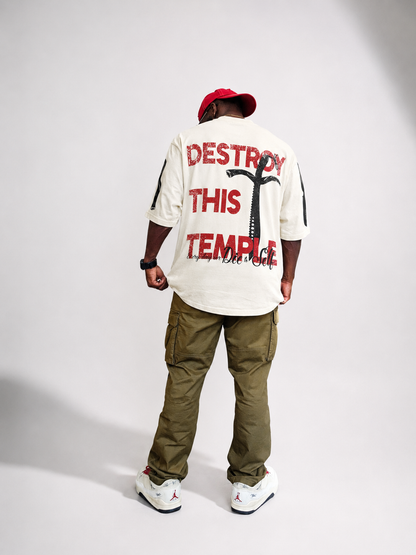Destroy This Temple® "The Motto" modeled, paired with olive cargo pant, and cream low-top sneakers.